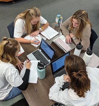 Sophomores Elena White, senior Lydia Serra, junior Katrina Costanzo, and sophomore Lily Palmer study in the library.