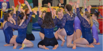 The LHS girls’ gymnastics kick off competition with a team cheer. Photo courtesy of Ava Stalter. 

