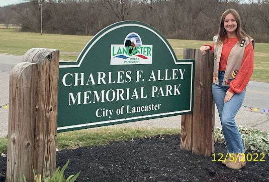 LHS junior Sara Kallenberg beside the Alley Park sign. Photo courtesy of Alley Park Sensory Trail Facebook page.