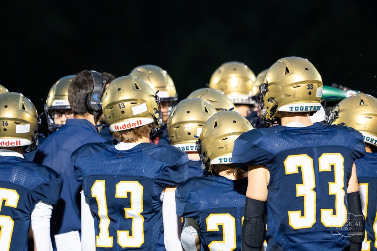 LHS Varsity football team huddles before a play.  Photo courtesy of Imagical Studios.